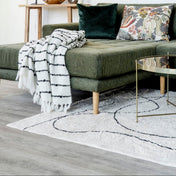 Modern living room with a green sofa, decorative pillows, and a coffee table.